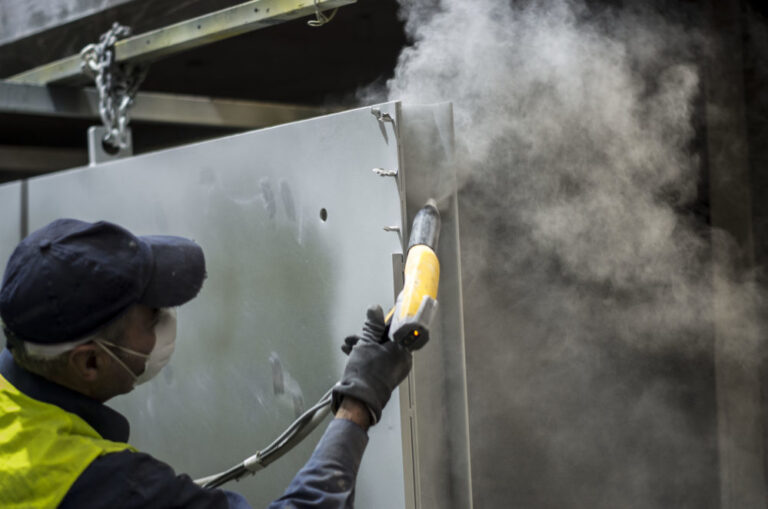 Técnico de D MUVLE fpintando fierros metálicos en taller de Padre Hurtado, Santiago